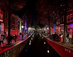 Crowds walking past window prostitution and other sex businesses along the Oudezijds Achterburgwal canal in De Wallen