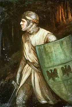 A medieval warrior clad in chain mail and a cream-coloured surcoat stands alert in a dark forest, gazing to his left with a focused expression. He wears a thick, golden band around the mail coif covering his head, and he holds a large green kite shield adorned with two black double-headed eagles, with a third apparently out of frame. A sword is visible in his right hand, partially drawn. The dim background features dense, shadowy trees.