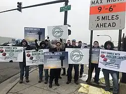 PASS members outside holding signs that say Don't Gamble with Aviation Safety and Aviation Safety is Our Only Business.