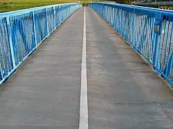 First-person perspective view, looking along the deck of the Bay Farm Island Bicycle Bridge