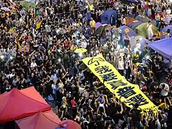 Hong Kong protesters holding a banner reading "I want real universal suffrage."