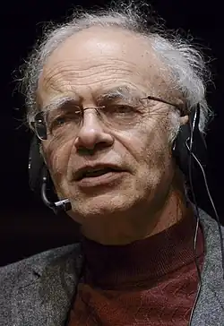 Photo of a man with gray hair speaking through a headset