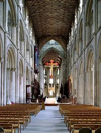 The nave of Peterborough Cathedral is in three stages supporting a rare wooden ceiling retaining its original decoration.