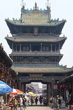 A multi-storey Chinese tower with people passing underneath