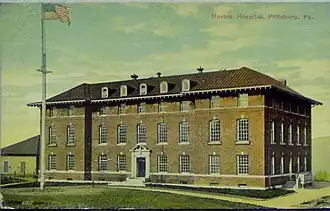 A color postcard showing a three-and-a-half-story brick building with a pitched roof