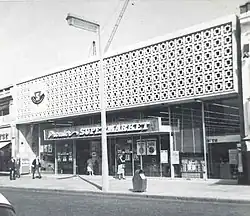 Premier Supermarket on Station Road (1963), now an Iceland supermarket; the site was originally home to the Harrow Coliseum cinema which was demolished in 1956[100]