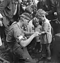 Canadian Private MacDonald gives first aid to a child