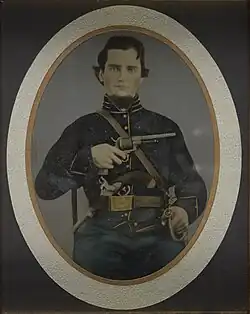 A tinype of a soldier from the American Civil War, depicted seated and holding a Lefaucheux M1858