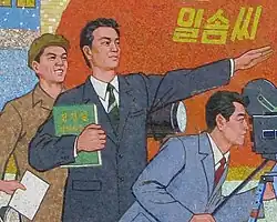 A detail of a mural wherein a filmmaker holds a copy of On the Art of the Cinema and gestures to the distance.