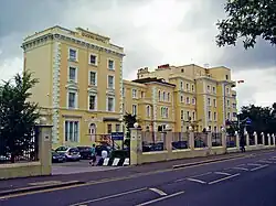 Photograph of front of Georgian-style white/cream Queen's Hotel building.