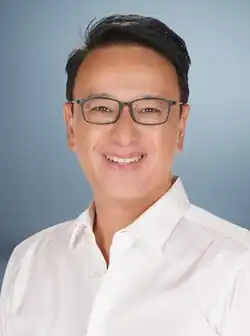 Quimbo in 2025 wearing a white polo and square glasses