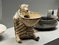Painted pottery vessel in the form of a seated bear-like creature, with a large bowl beneath its chin