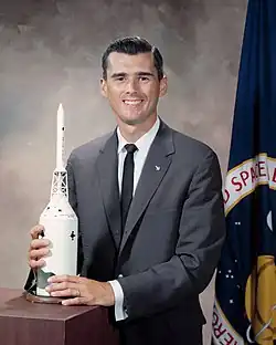 Portrait of Chaffee smiling with a spacecraft model