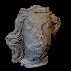 Stone sculpture of head with long flowing hair