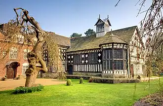 Exterior of large black=and white Tudor house