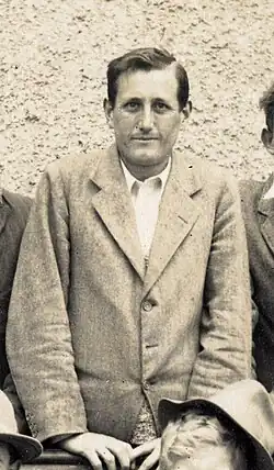 Wiliam King standing for a group photograph. He is wearing a jacket.