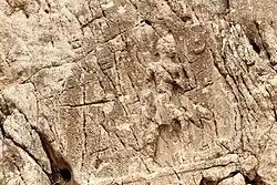 Sarpol-e Zahab, relief I. Beardless warrior with axe, trampling a foe. Sundisk above. A name "Zaba(zuna), son of ..." can be read. He is usually considered as a ruler of the Lullubi,[9][10] but he could be a ruler of the Kingdom of Simurrum, son of Iddi(n)-Sin.[6]