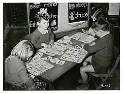 Four children sat at a table working on puzzles.