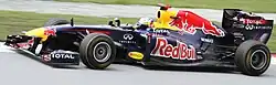 Photo of Sebastian Vettel driving a blue Red Bull car on a race track