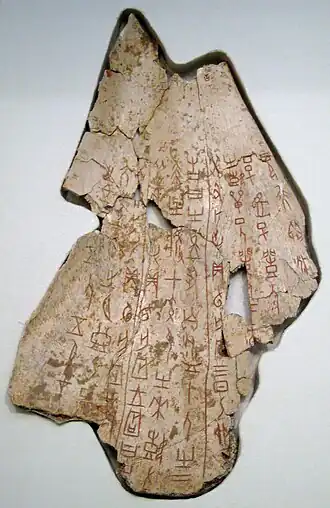 Photograph of bone fragment with carved characters