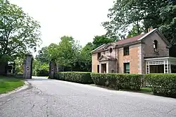 A driveway, gate, and small gatehouse