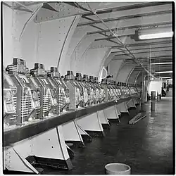 A row of metallic slot machines leading to a vanishing point at the distant end of a hallway