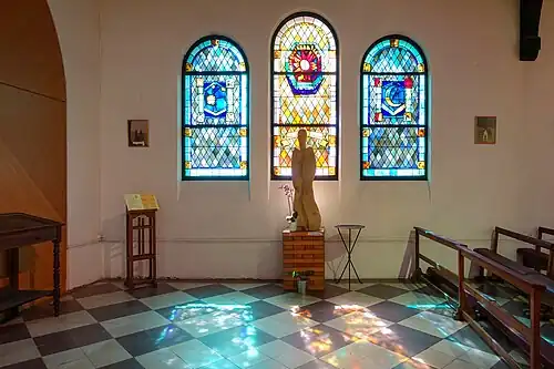 Chapel windows, left to right, "The stars","The sun" and "The moon". Statue is the Virgin Mary