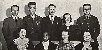 Group photograph of four men and one woman on the back row and four seated women in front. Harris, the only Black woman, is in the front row 2nd seat from the left.