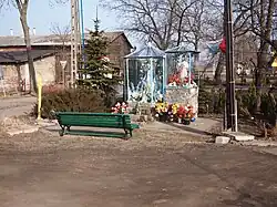 A bench in front of two wayside shrines in the village