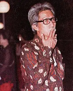 Film director Teguh Karya, standing with a cigarette in his mouth