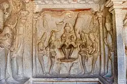 Square, carved wall with a number of figures