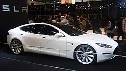A front three-quarters view, taken indoors, of a Tesla Model S prototype.