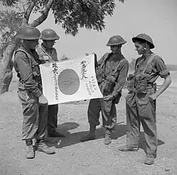 Four soldiers of the British Army's Worcestershire Regiment display a Good Luck Flag captured on Mount Popa during the mop-up operations that took place after the capture of Mandalay