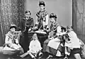 The Hessian children in July 1878. Left to right: Princess Irene, seated; Prince Ernest Louis wearing sailor suit, standing; Princess Marie, seated; Princess Elizabeth, standing behind writing desk; Princess Victoria, seated at writing desk; Princess Alix, seated.