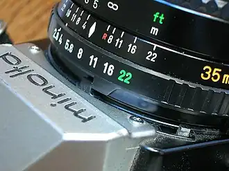 As the lens is stopped down, the in-camera meter is able to determine the aperture that was set (in this case, f/8) by the displacement of the black metering tab.