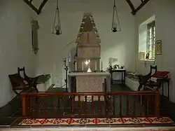 View of the chancel, with Melangell's shrine and the altar at the centre. The two effigies are visible on either side, and the door to the grave chapel is visible in the back.