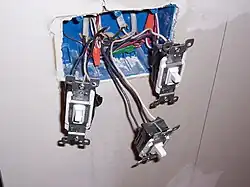 Three light switches in square wall box