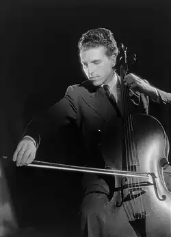 clean-shaven, slim white man with aquiline features, seen profile playing the cello