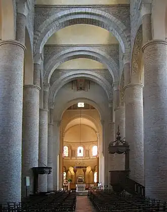 The Church of St. Philibert, Tournus, has tall circular piers and is roofed with transverse arches supporting a series of barrel vaults.