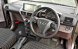 Dashboard of a car with an automatic gearbox, front airbags, satellite navigation, analogue and digital gauges, and rotary controls for the fan and heater