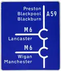 Advance direction sign on the immediate approach to a junction with the motorway which incorporates two roundabouts.
