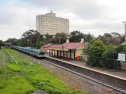 An old station viewed from further away with an apartment building in the background
