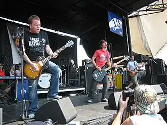 The Starting Line performing onstage playing and singing into a microphone