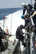 Sailors of USS Gettysburg assist crew members of RSS Persistence in the Gulf of Aden on 17 May 2009.
