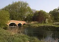 A jumped red-brick bridge over a river