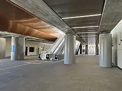 The interior of a station entrance building underneath a rail viaduct