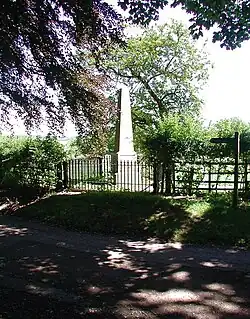Memorial obelisk in roadside field.