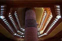 The living room's roof as seen from below. There are three bands of clerestory windows on the roof. In the center is a round chimney shaft