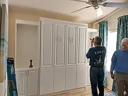 Workers installing a pull-down bed