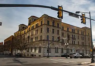 Large four-story brick building seen at an angle from the street intersection